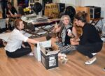 Volunteers Addy Baney, Julia Diamond, and Marie Pochitaloff labeling the wine